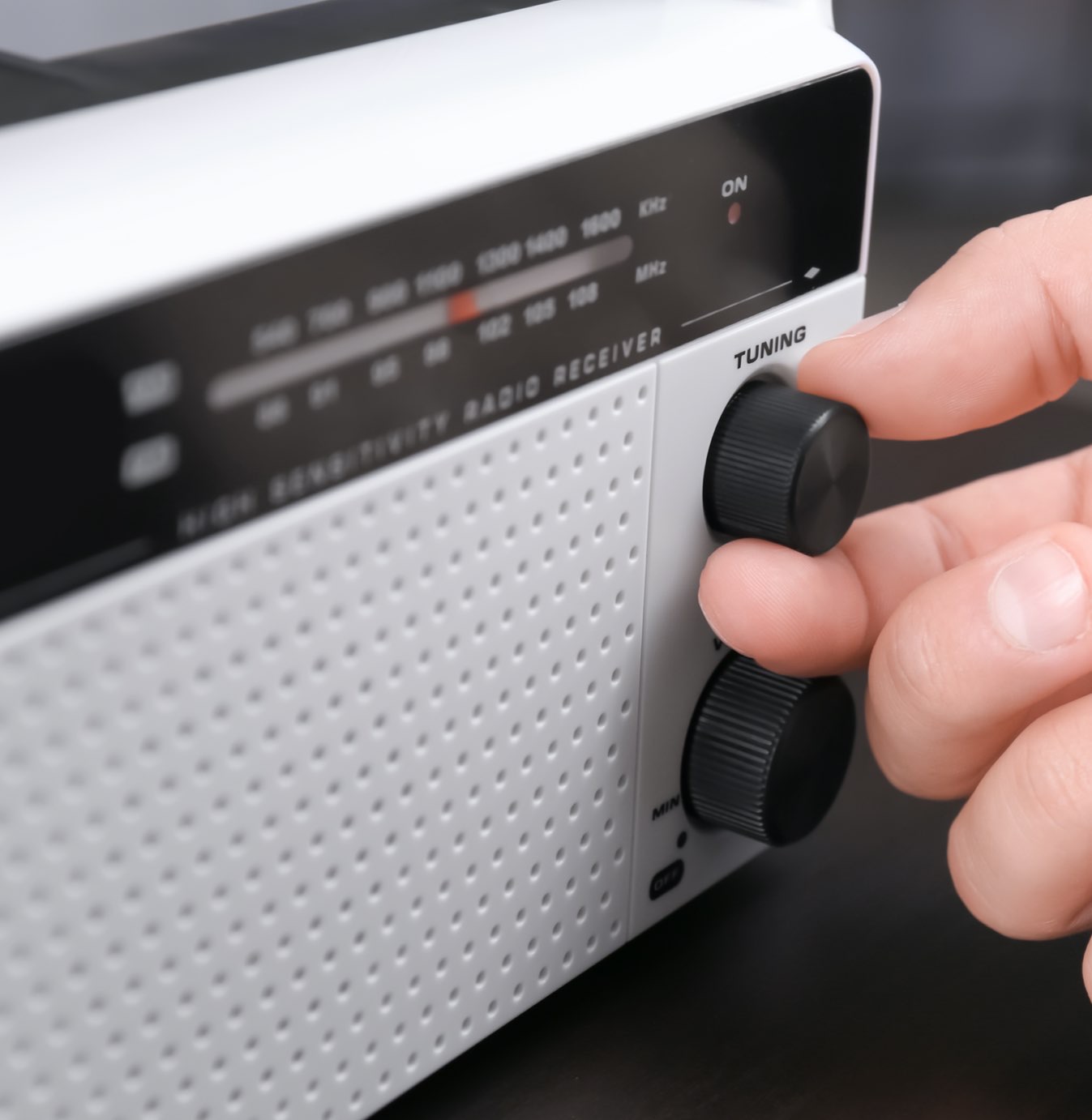 a man adjusting a radio dial